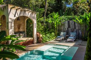 a backyard with a swimming pool and a patio with chairs at Hotel Boutique Perainda in Trancoso