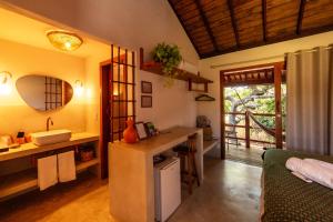 a bathroom with a sink and a counter in a room at Maria Chico Pousada in Caraíva