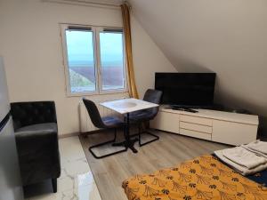 a small room with a table and a bed and a window at Appartement Confort avec parkings gratuits in Andolsheim