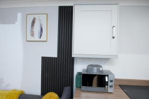 a kitchen with a microwave and a white cabinet at 2 Bed Apartment with all amenities in Stifford +9 photos