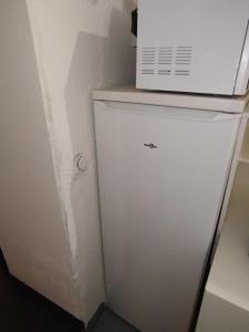 a microwave sitting on top of a white refrigerator at Dortoir en partage lit individuel in Bagnols-sur-Cèze