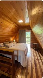a bedroom with a large bed in a wooden ceiling at Chalé Pôr do Sol 1 in Nova Veneza