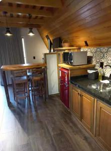 a kitchen with wooden cabinets and a counter top at Chalé Pôr do Sol 1 in Nova Veneza
