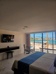 a bedroom with a bed and a desk with a view of the beach at Plaza Lobos in Puerto Baquerizo Moreno