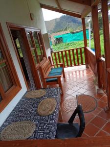 a balcony of a house with a table and a chair at Sol y Luna Villa Campestre in Iza