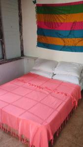 - un lit avec une couverture rose dans l'établissement Tubarao, à Búzios
