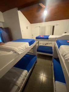 une chambre avec trois lits superposés dans une pièce dans l'établissement Tubarao, à Búzios