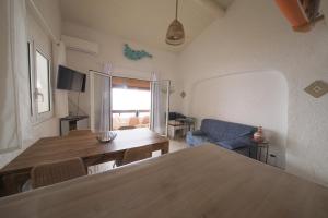 a living room with a table and a blue couch at Villa Sognu di Mare in Conca