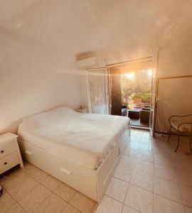 a bedroom with a white bed and a balcony at Villa Sognu di Mare in Conca