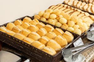 a bunch of bread in trays on a table at Hotel Euro Suite Campinas by Nacional Inn - Próximo ao Cambuí in Campinas