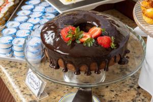 a chocolate cake with strawberries on top on a plate at Hotel Euro Suite Campinas by Nacional Inn - Próximo ao Cambuí in Campinas