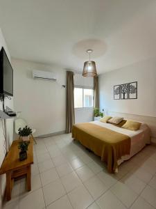 サルタにあるPlaza 9 de Julio Suitesの大きなベッドとテレビのある寝室