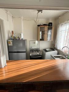 a kitchen with a stove and a refrigerator at Casa Punta Arenas ubicación central in Punta Arenas