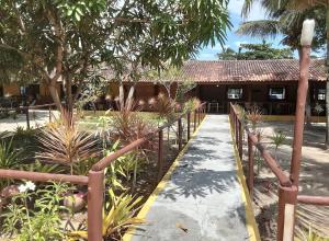 a path leading to a house with a fence at Patipe Praia Hotel in Canavieiras