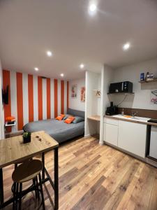 a bedroom with a bed and a table and a kitchen at Le Spritz in Chalon-sur-Saône