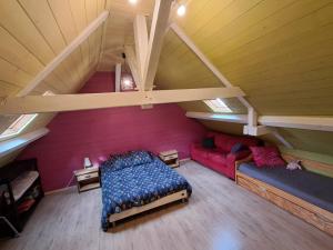 オロロン・サント・マリーにあるMaison de ville au cœur du quartier historiqueのベッドルーム1室(ベッド1台、屋根裏部屋のソファ付)