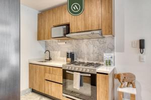 a kitchen with a stove and a microwave at Centric 2 BR Condo - Gym - Open Air Cinema in Mexico City