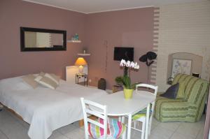 een slaapkamer met een bed, een tafel en een stoel bij Le Campanin in Menton