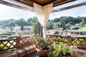 een balkon met potplanten en uitzicht op een stad bij Sunny Treasure - cozy & quiet , close to Roma, Bambin Gesù, Passoscuro, Fregene e Maccarese in Aranova
