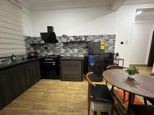 North LegonにあるFlintsky Residenceの黒い家電製品とテーブルと椅子のあるキッチン