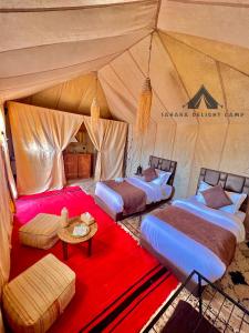 a group of four beds in a tent at Sahara Delight Camp in Merzouga