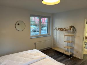 a bedroom with a bed and a window and a shelf at Im Herzen der Eifel - Entspannung pur in Hellenthal