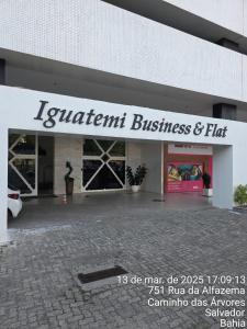 un bâtiment avec un panneau indiquant l'entreprise et l'appartement dans l'établissement Bahia Iguatemi Business Flats, à Salvador
