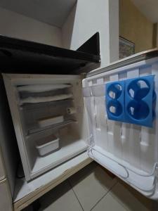 - un réfrigérateur vide avec un panneau bleu dans l'établissement Bahia Iguatemi Business Flats, à Salvador