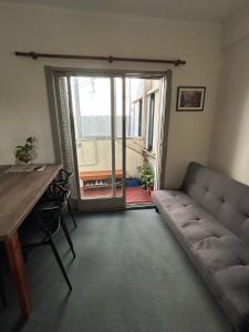 ein Wohnzimmer mit einer Couch und einem Tisch und einem Fenster in der Unterkunft Departamento 1 dormitorio in Santa Fe