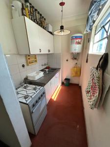 eine kleine Küche mit einem Herd und weißen Schränken in der Unterkunft Departamento 1 dormitorio in Santa Fe