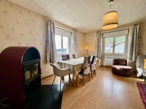 a living room with a table and chairs and a fireplace at Le Cresson, charmant et spacieux avec balcon in Gérardmer