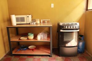 a small kitchen with a stove and a microwave at Hostal Casa Nómada in Santa Ana
