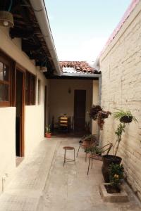 an outdoor patio with chairs and a brick wall at Hostal Casa Nómada in Santa Ana