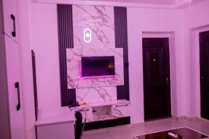 Camera con parete in marmo rosa e TV. di Skyrock Hotels Ikeja a Ikeja