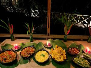 a table topped with different types of food and candles at Kurrulau Hotel Playa Pacífica in Nabugá