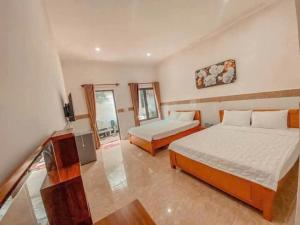 a bedroom with two beds and a television in it at Đạt Ngọc Hotel in Ấp Thiện Long