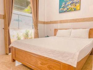a large bed in a bedroom with a window at Đạt Ngọc Hotel in Ấp Thiện Long