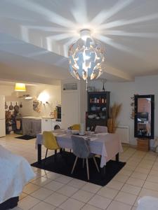 a dining room with a table and a chandelier at CHEZ ISA chambre chez l'habitant Emma in Montlouis-sur-Loire