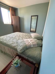 a bedroom with a bed and a mirror and a table at Pousada Pôr do Sol in Lapa