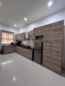 Kampong Batu MaungにあるNaura Homes Penangのキッチン(木製キャビネット、黒い冷蔵庫付)