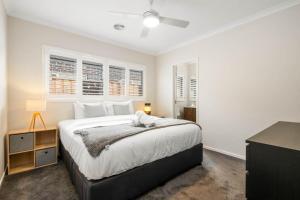 a bedroom with a large bed and two windows at Rowands Residence Mt Duneed in Mount Duneed