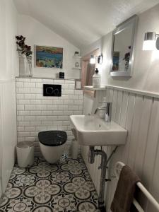 a small bathroom with a sink and a toilet at A pearl in the middle of Kvívík with a nice view in Kvívík