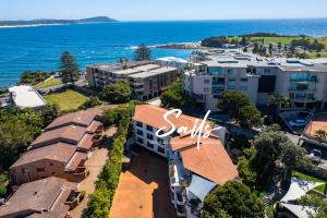 an aerial view of a building next to the ocean at Terrigal Sails Serviced Apartments in Terrigal