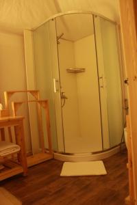 a glass shower in a room with a wooden floor at Albayt Private Camp in Wadi Rum