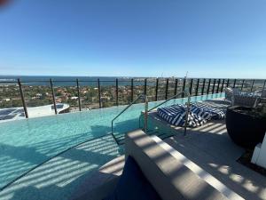 a swimming pool with a view of the ocean at Complete Host Nine Elm Apartments in Melbourne