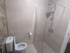 Un baño con inodoro y ducha de cristal. en Nos Cantin 1 double Bedroom, en Mindelo