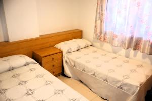 ein kleines Zimmer mit zwei Betten und einem Fenster in der Unterkunft Europeñiscola playavacaciones in Benicarló