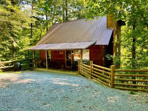 a red cabin with a fence in front of it at Great Expectations in Townsend
