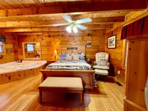 a log cabin bedroom with a bed and a tub at Bearfoot in Townsend