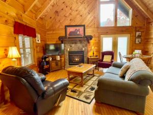a living room with leather furniture and a fireplace at Bearfoot in Townsend